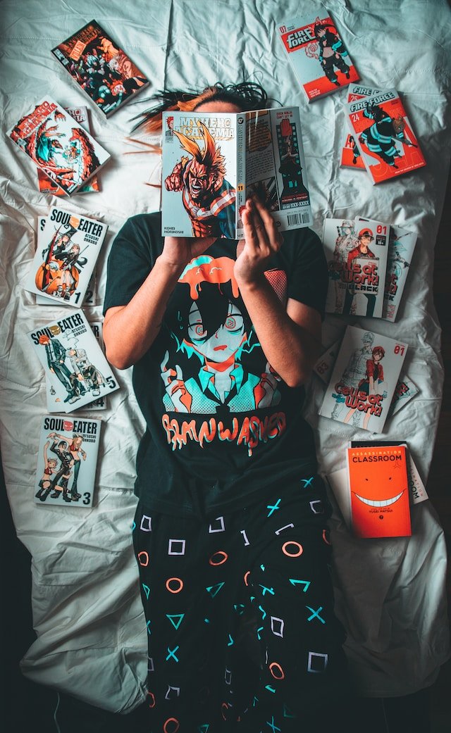 Image of person reading manga on the bed.