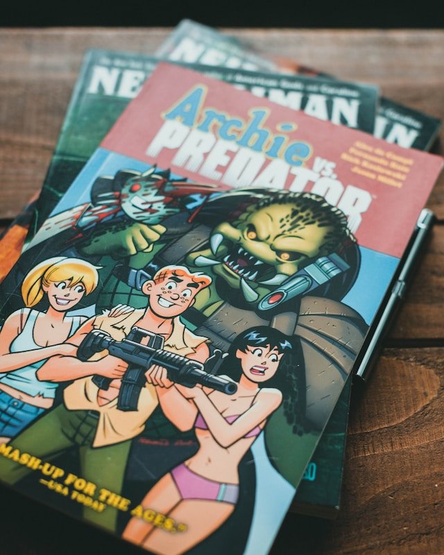 Image of three hardcovers, with Archie vs Predator on top.